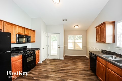A kitchen with wooden cabinets and black appliances.