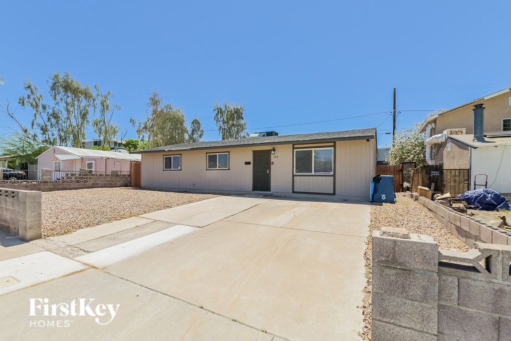 A house with a driveway and a garage door is for sale.