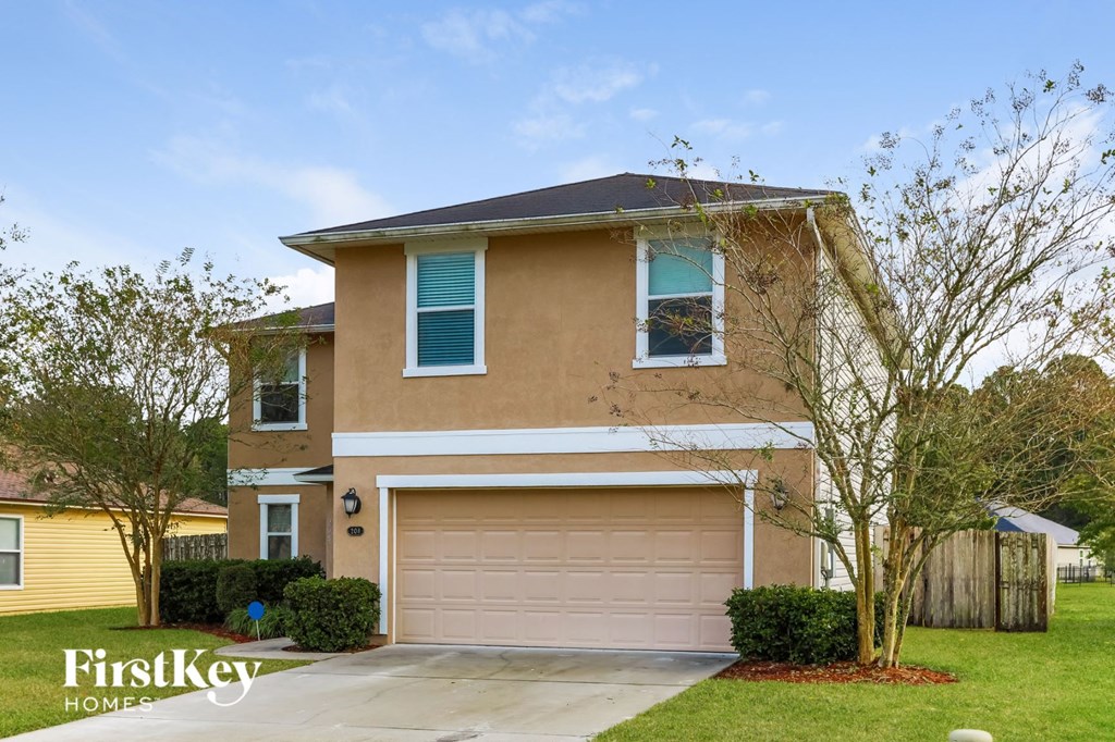 a house with a garage door and a lawn