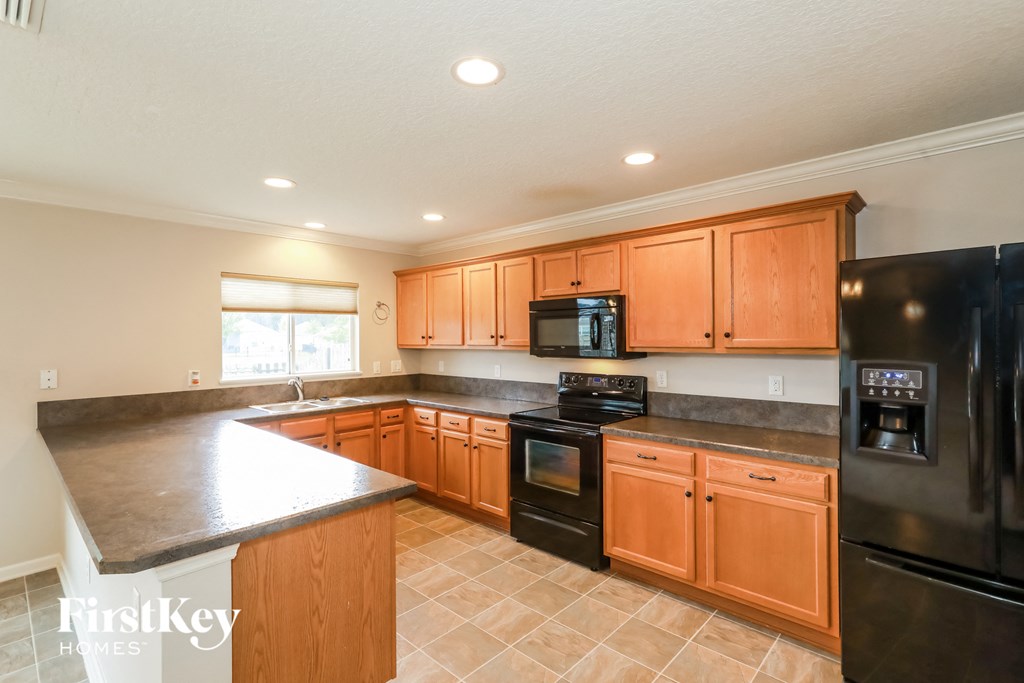 a kitchen with wooden cabinets and black appliances