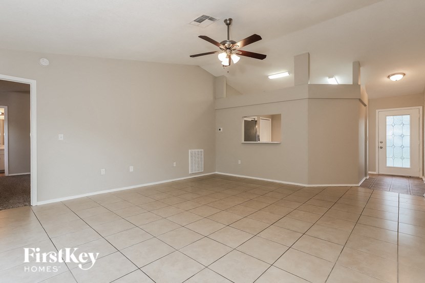 A spacious room with a ceiling fan and tiled flooring.