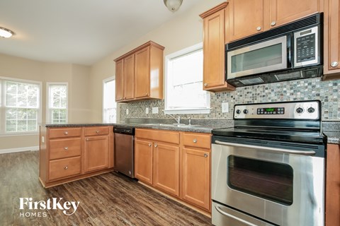 A kitchen with wooden cabinets and a black stove top oven.