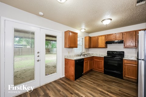 A kitchen with wooden cabinets and black appliances.