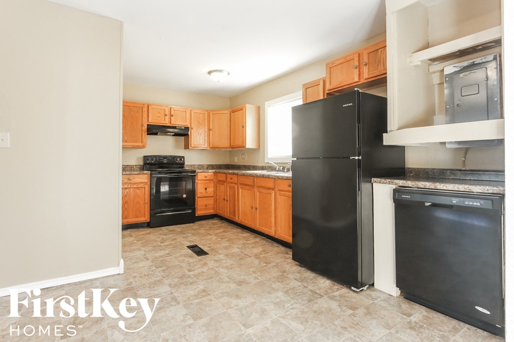 A kitchen with a black fridge and a black oven.