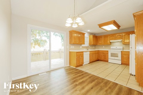 a kitchen with wooden cabinets and white appliances and a sliding glass door