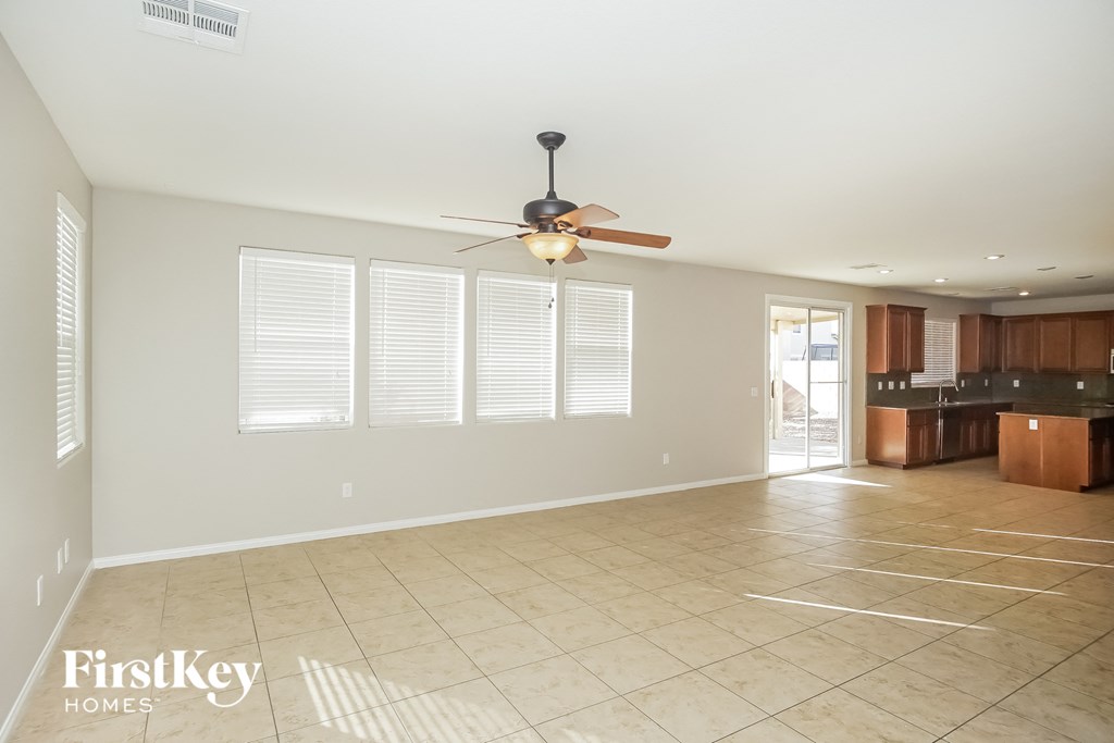 an empty kitchen and living room with a ceiling fan