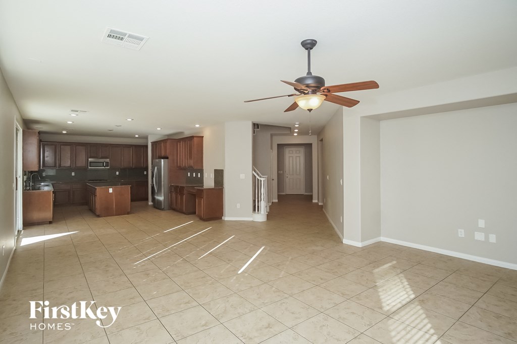 an empty kitchen and living room with a ceiling fan