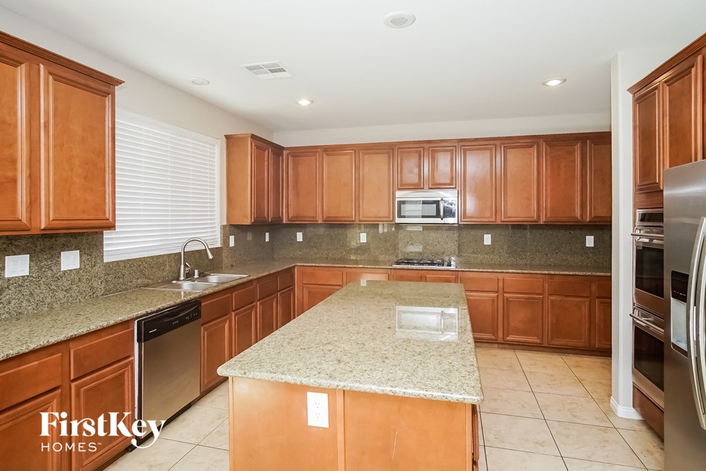 a kitchen with wooden cabinets and granite counter tops and a sink
