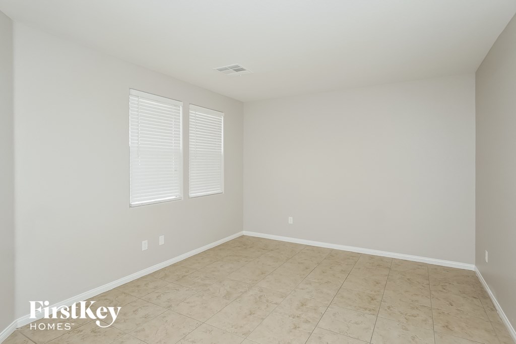 a empty room with a tiled floor and two windows
