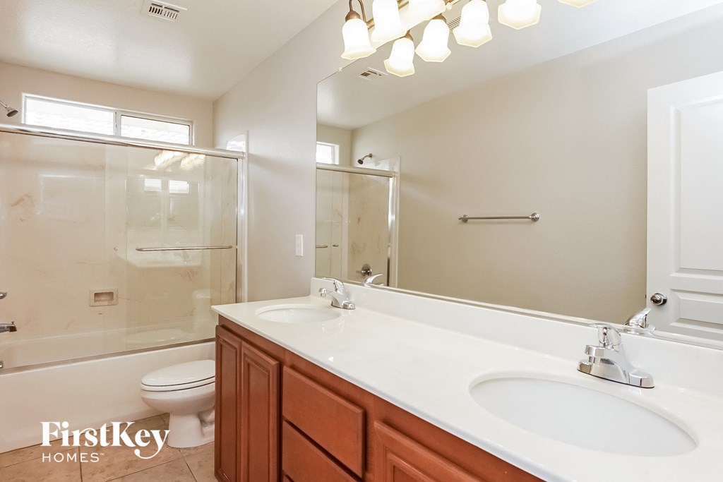a bathroom with two sinks and a shower and a toilet
