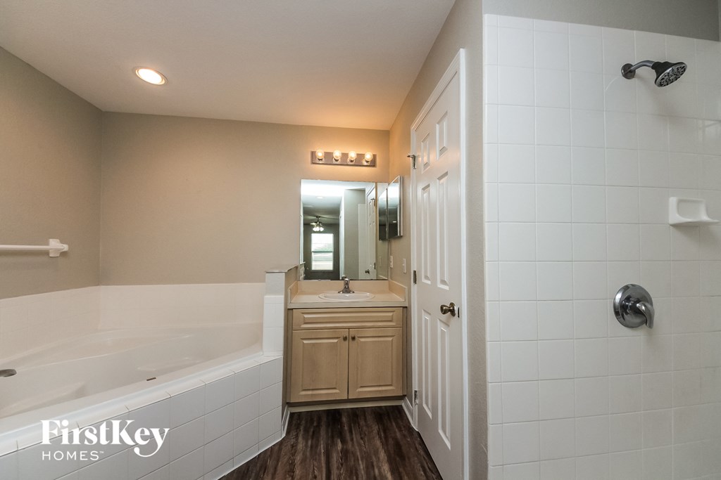 a bathroom with a tub and a sink and a mirror