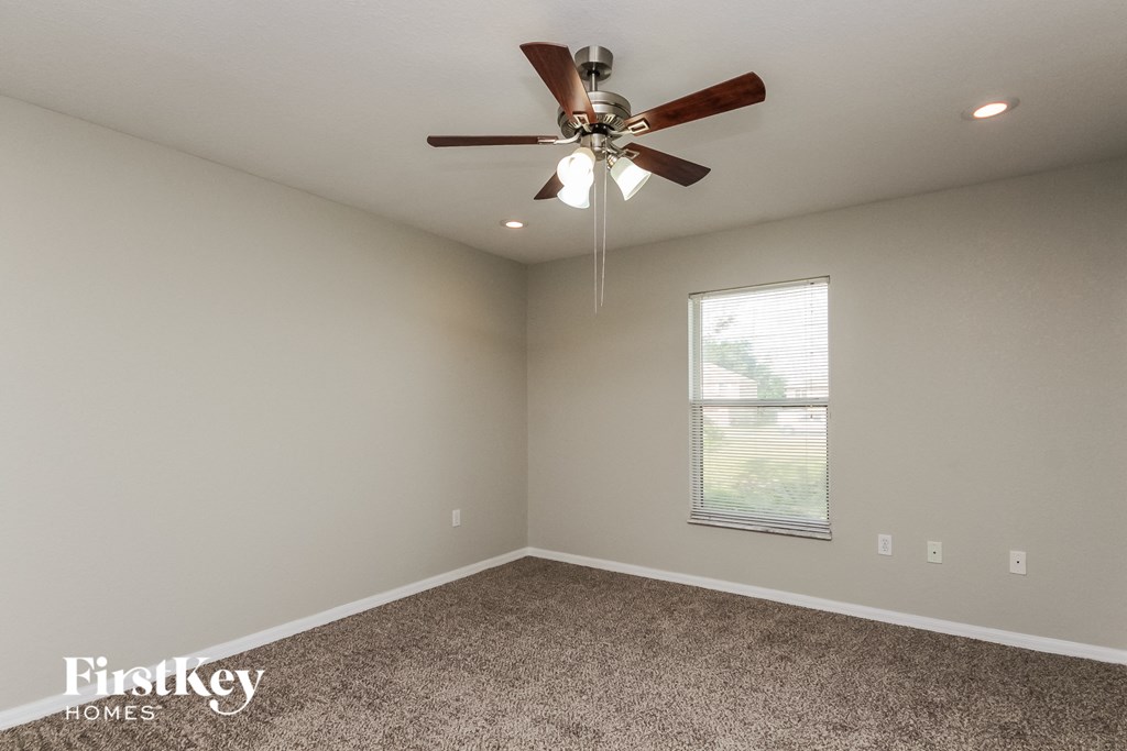 the living room has a ceiling fan and carpet