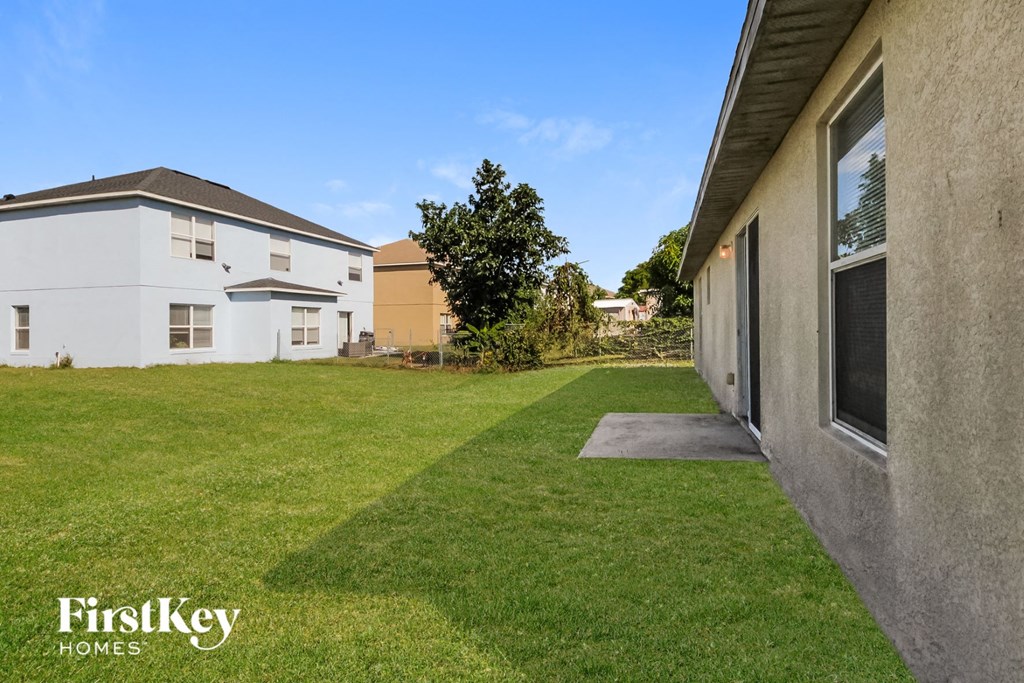 a backyard with a green lawn and two buildings