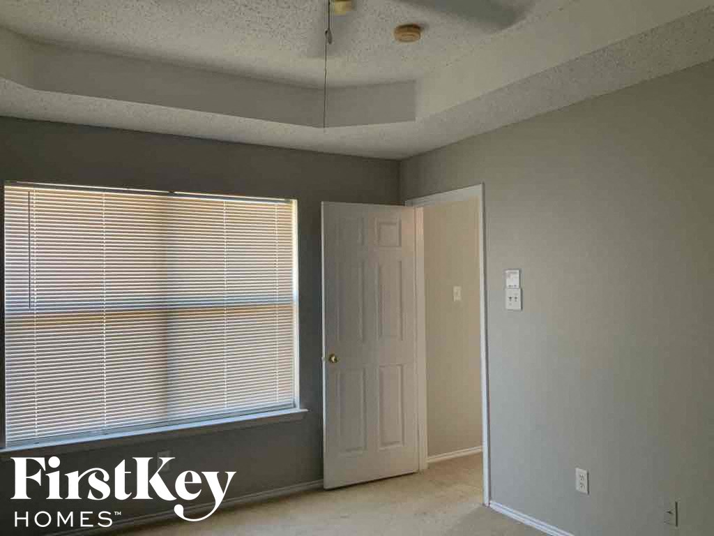 an empty living room with a large window and a white door