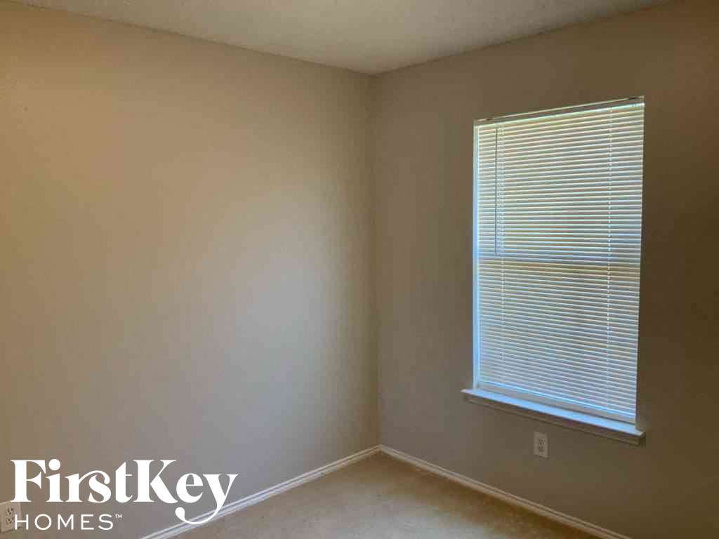 a small room with a window and a white wall