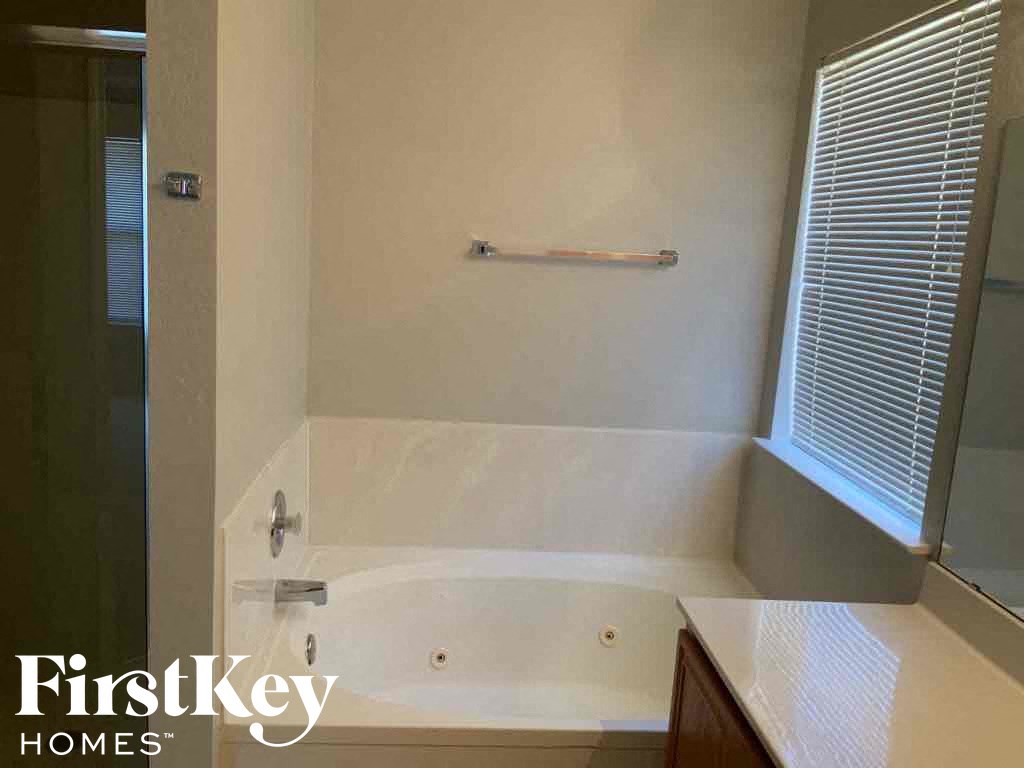 a bathroom with a tub and a shower and a window