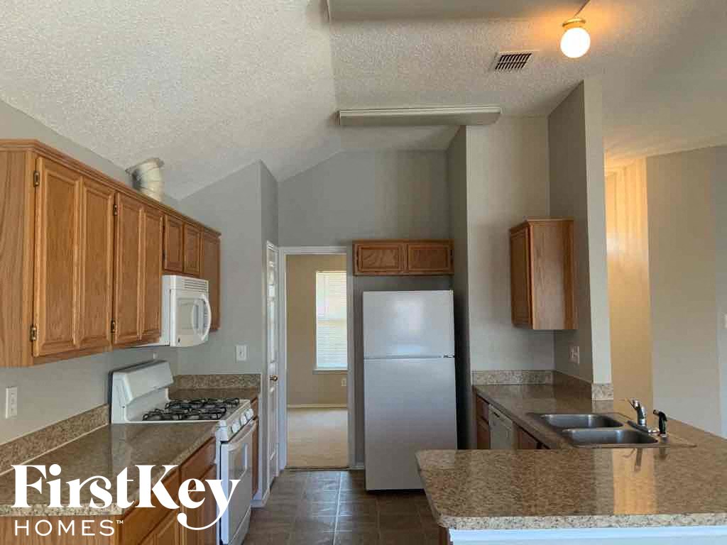 an empty kitchen with a refrigerator and a sink