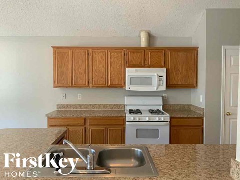 a kitchen with a sink stove and microwave