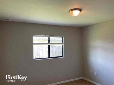 an empty room with a window and a light on the ceiling