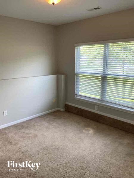a bedroom with a large window and a carpeted floor