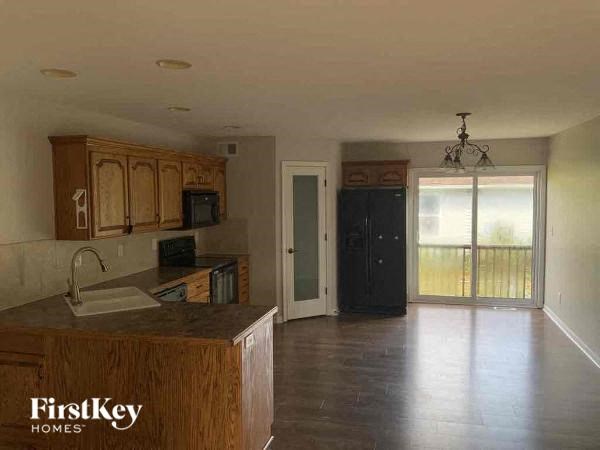 an empty kitchen with wooden cabinets and a sink