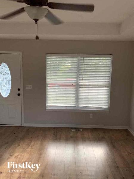 a living room with a ceiling fan and a window