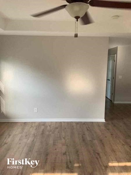 an empty living room with a ceiling fan