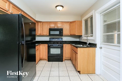 A kitchen with wooden cabinets and black appliances.