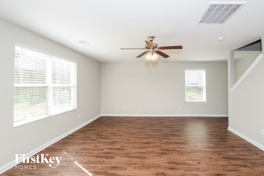 a living room with wood floors and a ceiling fan