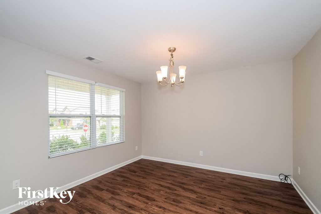 a living room with a wood floor and a large window