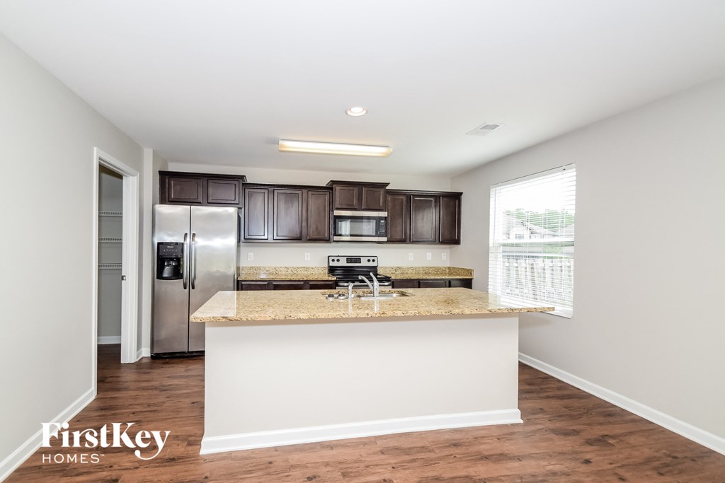 a kitchen with a granite counter top and a stainless steel refrigerator