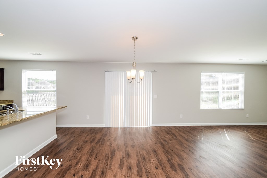 an empty living room with wood floors and white walls