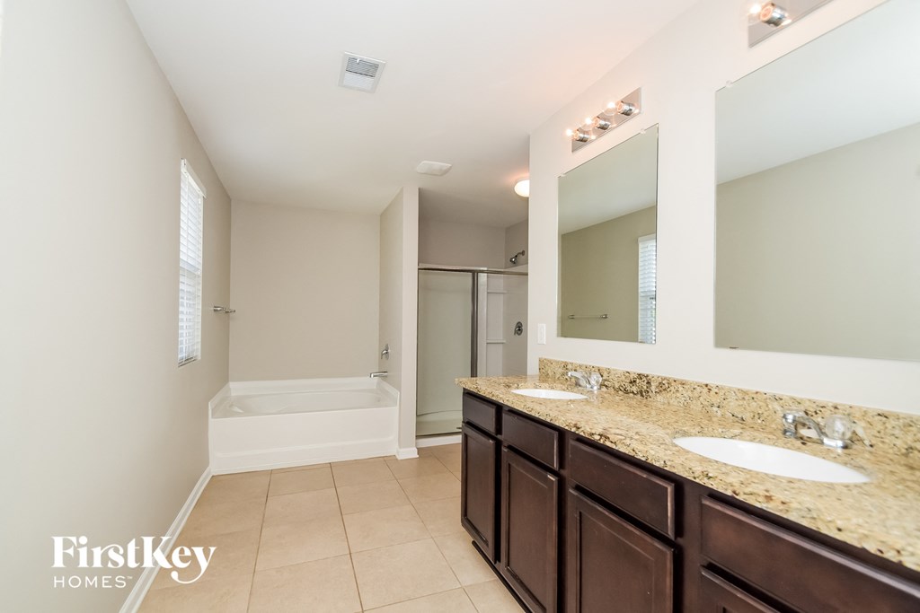 a bathroom with two sinks and a tub and a shower and a sink and mirror