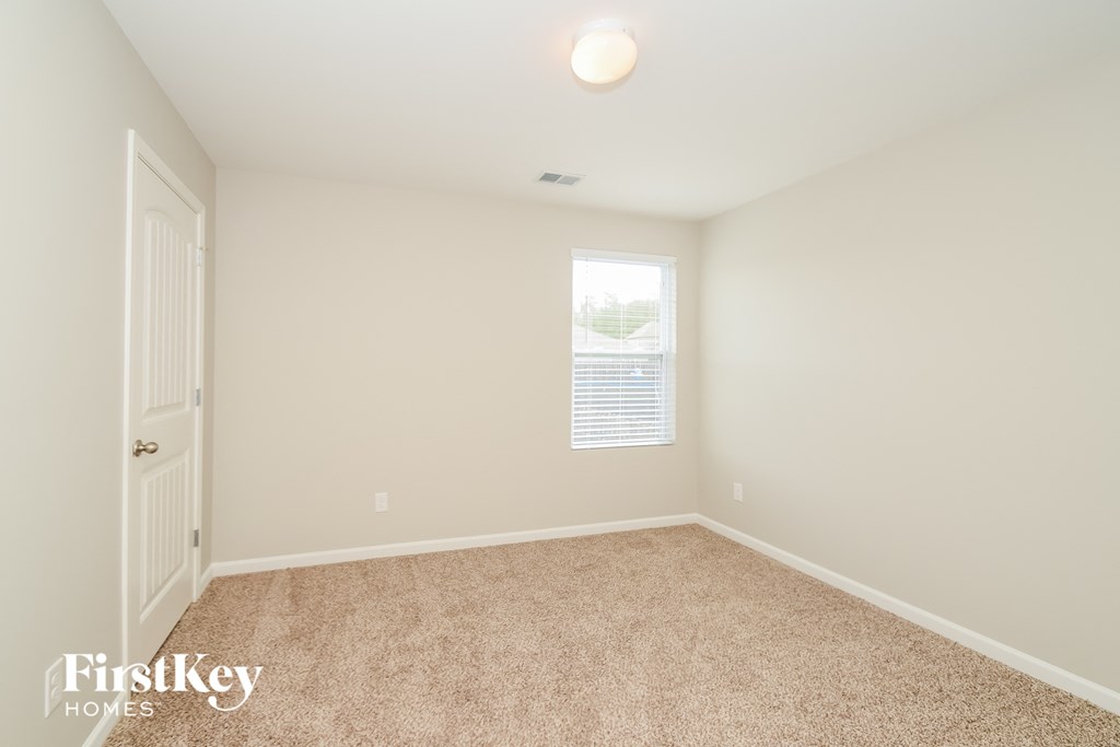 a spacious room with carpet and a window