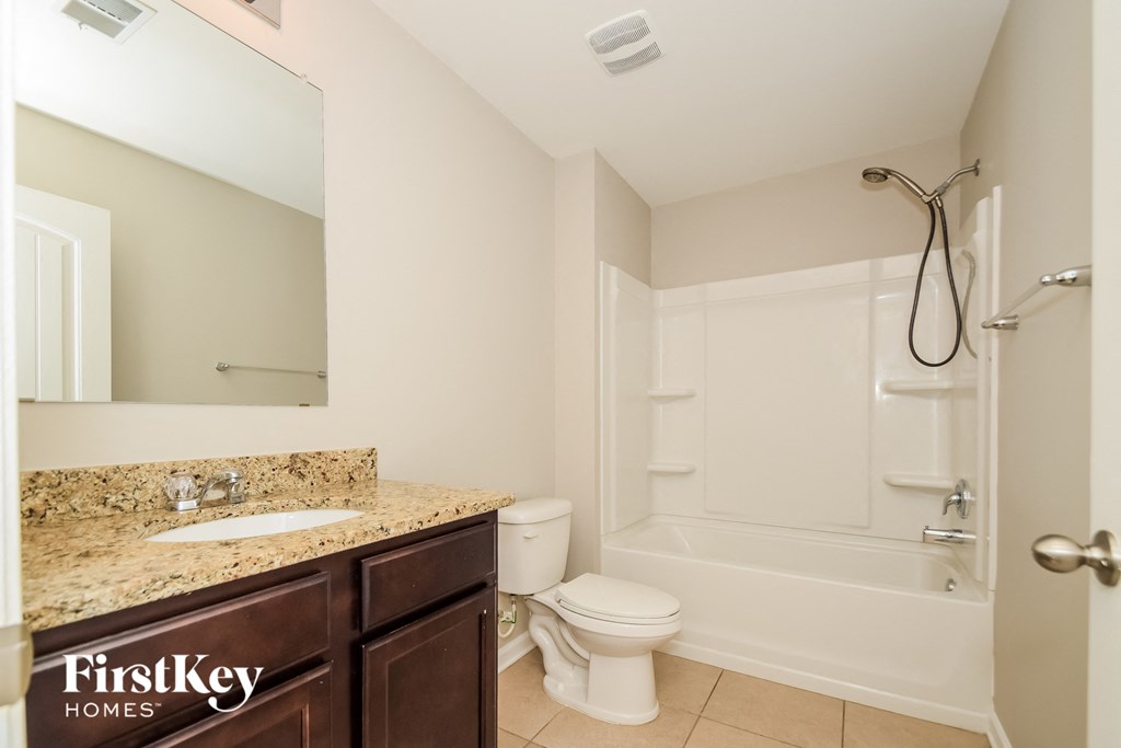 a bathroom with a shower toilet and sink and a mirror