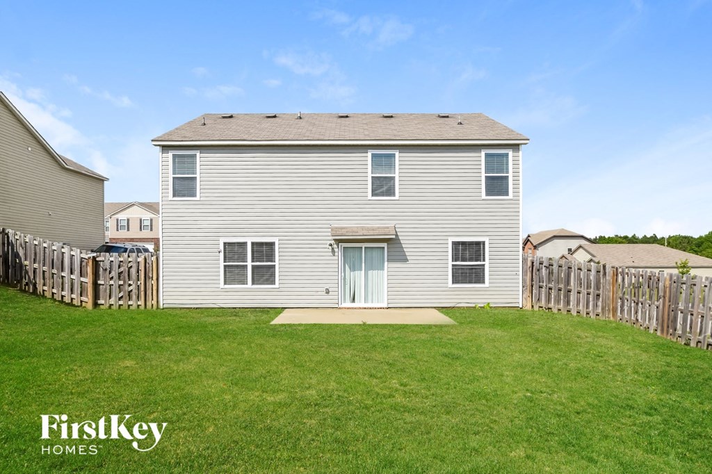 a white house with a yard and a wooden fence