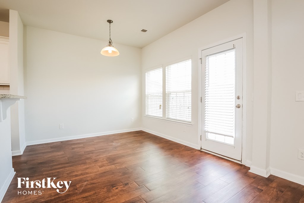 A room with wooden floors and a light hanging from the ceiling.