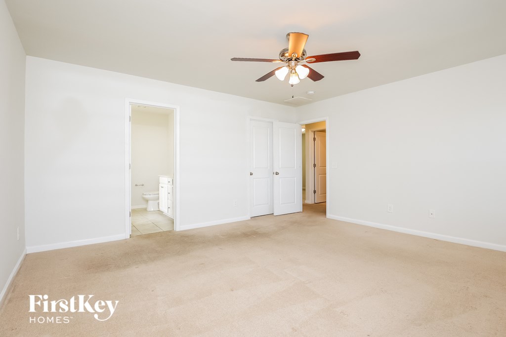 A room with a ceiling fan and a carpeted floor.