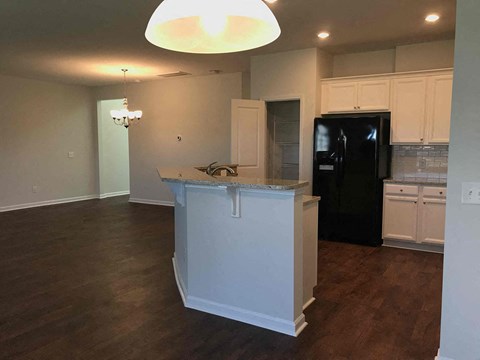 a kitchen with a center island and a black refrigerator