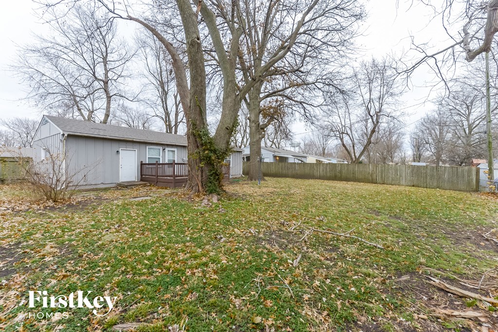A backyard with a shed and a fence.