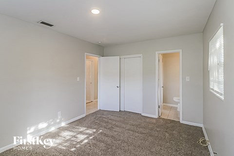 a living room with a carpet and a door to a bathroom