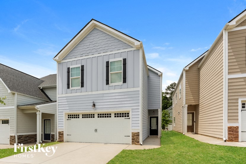 A modern house with a garage is part of a FirstKey Homes development.