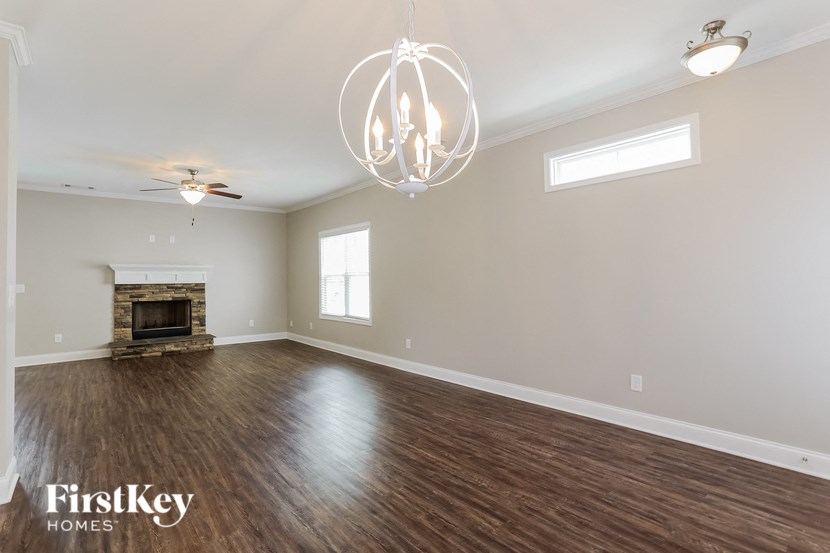 A spacious room with a fireplace and a chandelier.