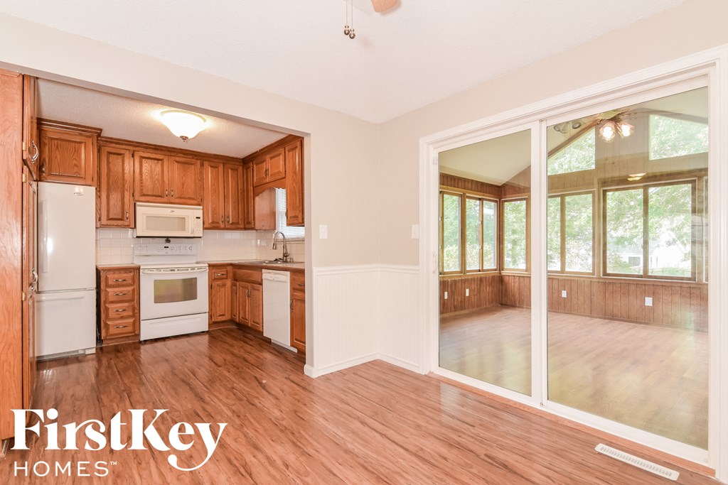 A kitchen with wooden cabinets and a white fridge is shown.