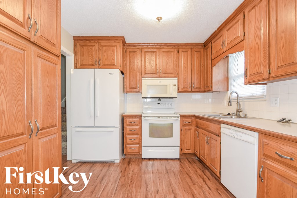 A kitchen with wooden cabinets and white appliances.