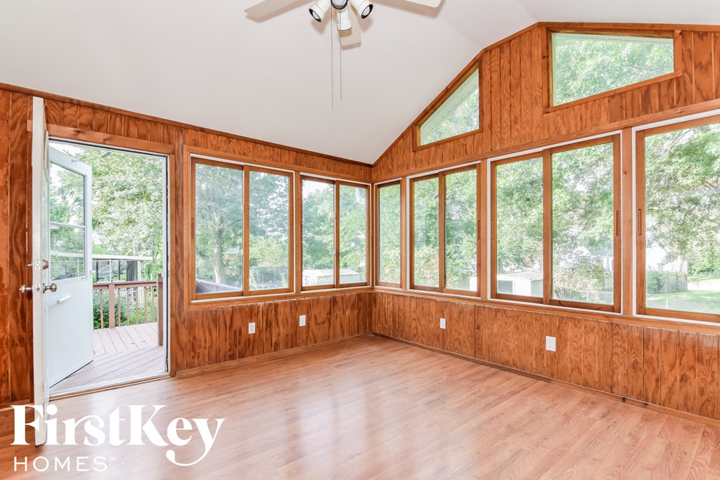 A room with wooden walls and a ceiling fan.