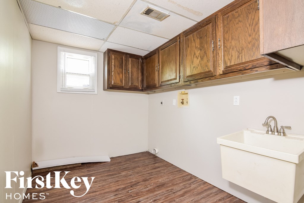 A bathroom with wooden cabinets and a white sink.