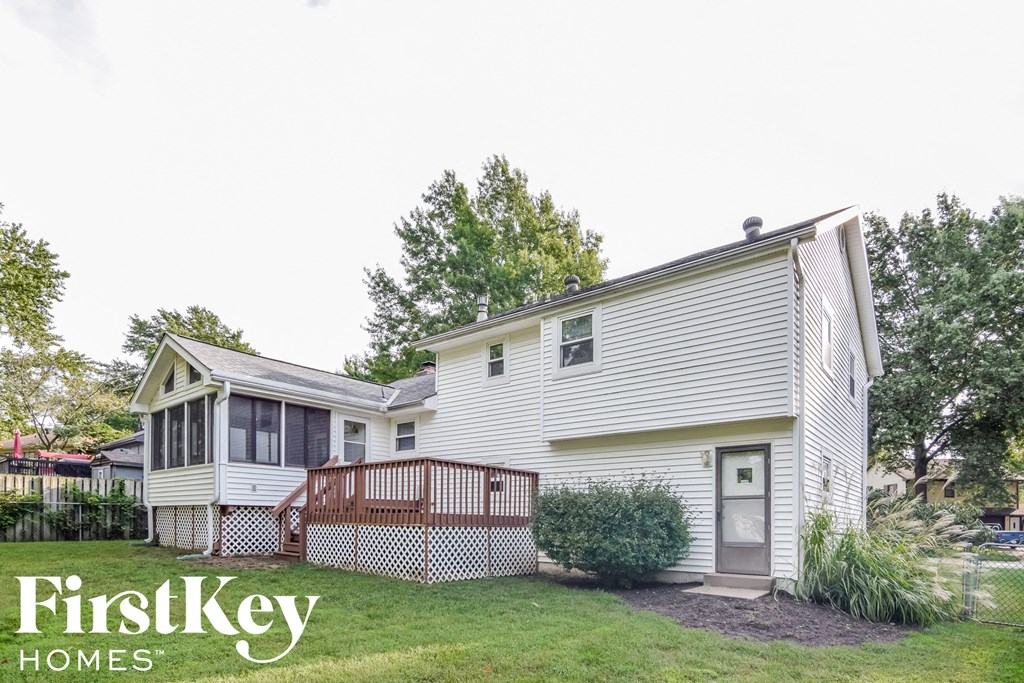 A white house with a grey door and a small porch.