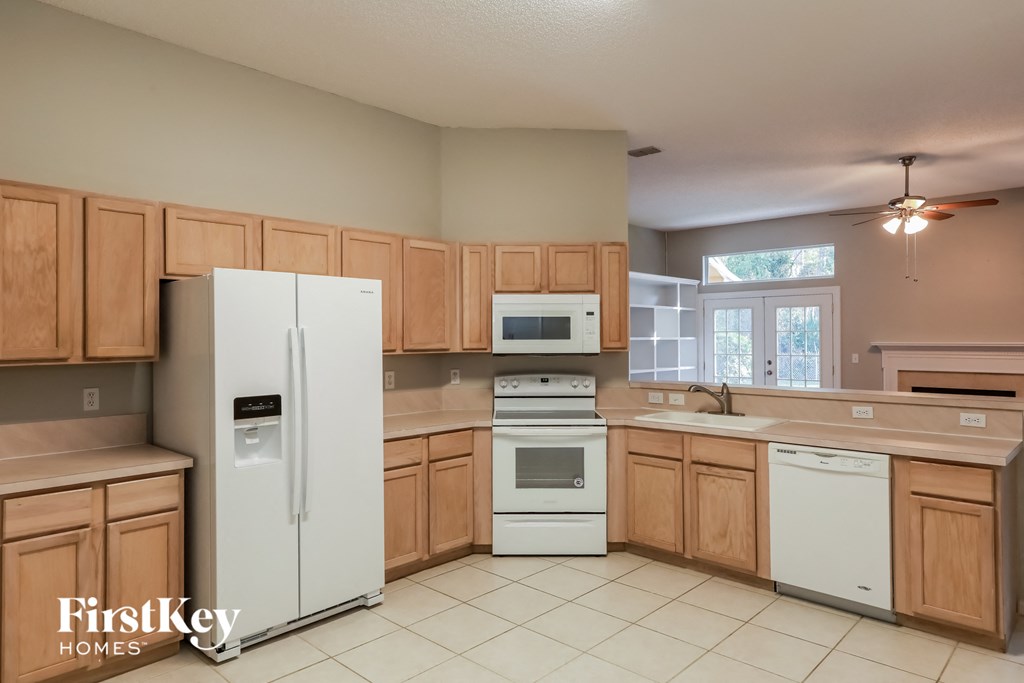a kitchen with white appliances and wooden cabinets