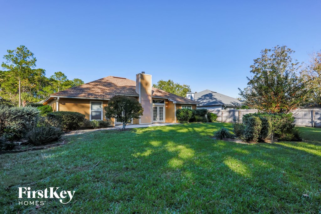 a backyard with a house and a green lawn